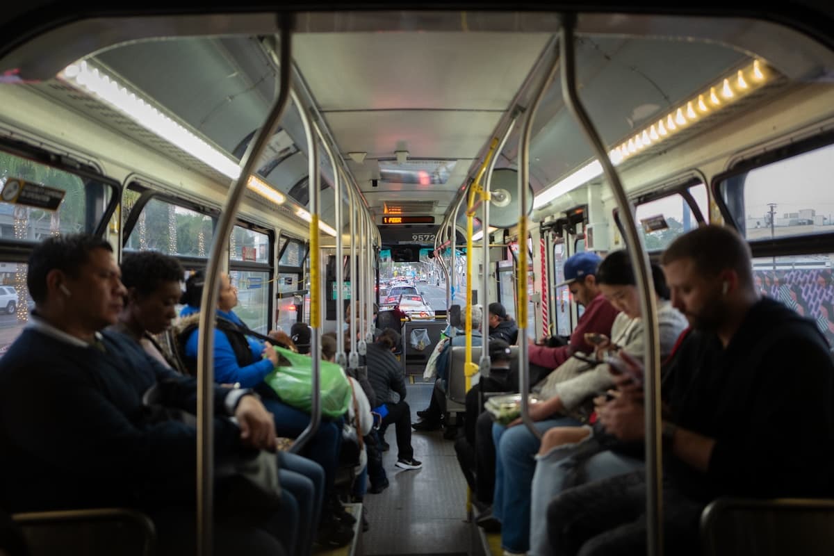 Inside of bus with many passengers sitting