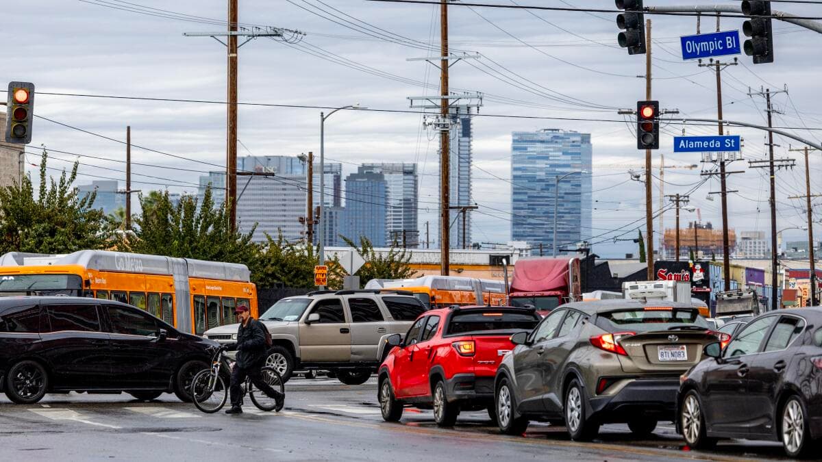 Road with cars, buses, truck, and a person walking their bike