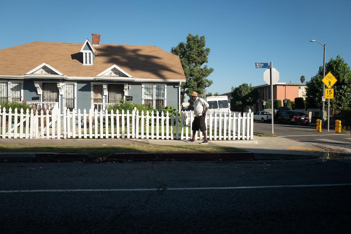 House with picket fences and a person walking in front